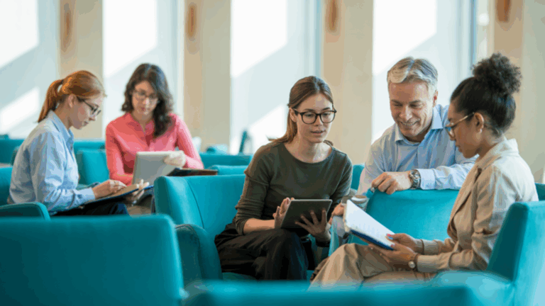 Estudantes utilizando computadores para acessar acervos online em uma biblioteca digital.